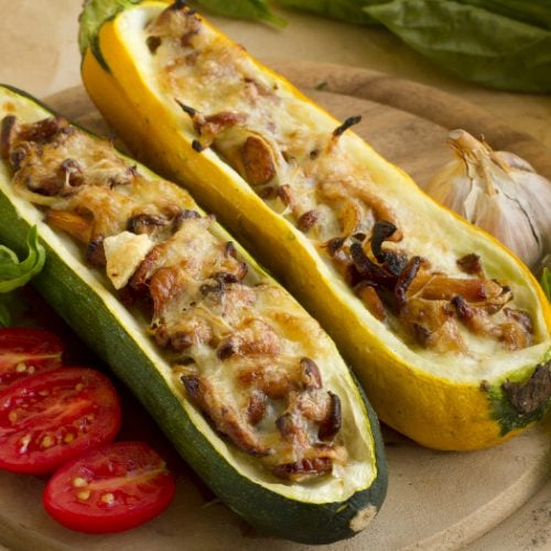 Stuffed summer squash with mushrooms and cheese on a wooden plate