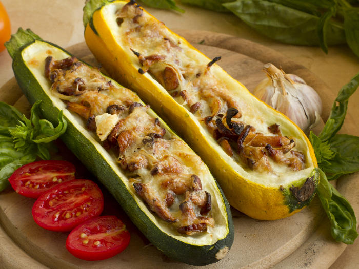 Stuffed summer squash with mushrooms and cheese on a wooden plate