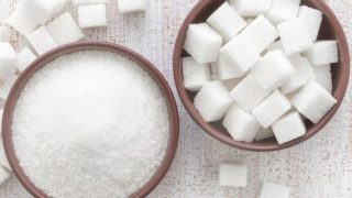 Sugar cubes and ground sugar in two different bowls