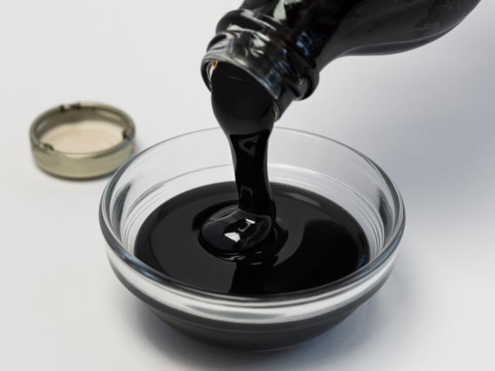 Pouring molasses from a bottle into a bowl