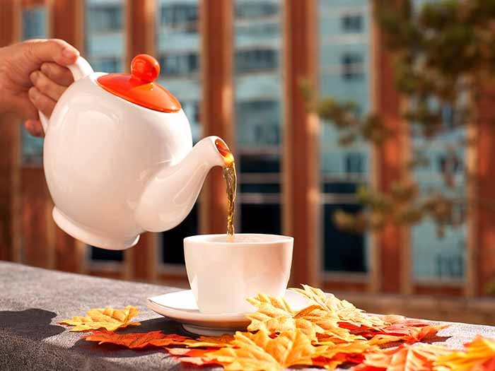 Pouring tea through a kettle into a cup