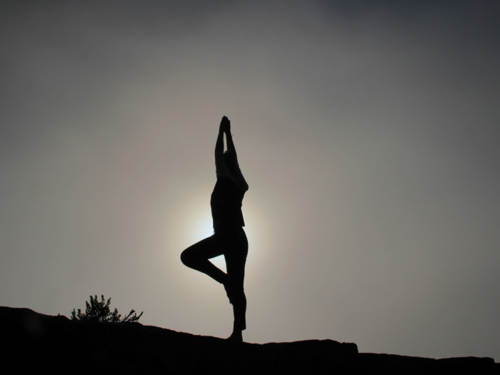 A black and white silhouette of a person performing Surya Namaskar