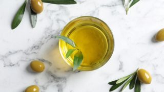 Flat lay composition with fresh sweet oil or olive oil on a marble background