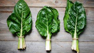 Close-up of fresh green Swiss chard on a wooden table