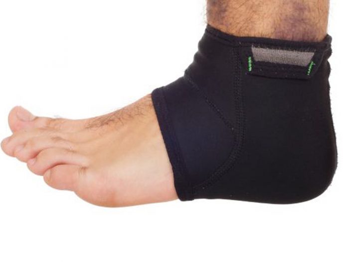 A man's swollen ankle tied up with a black color crepe bandage