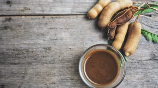 A flat lay picture of tamarind sauce kept on a wooden background