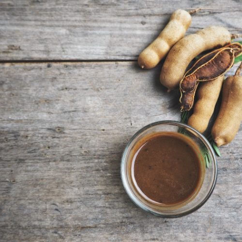 A flat lay picture of tamarind sauce kept on a wooden background