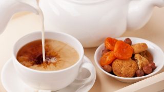 Milk being poured into a cup of strong Irish tea