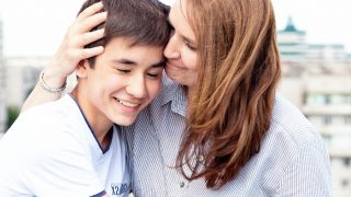 A teenage boy hugging his mother