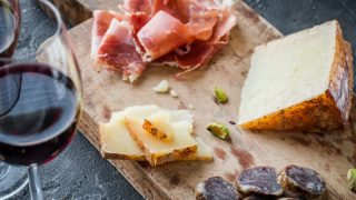 Red wine with an array of Spanish appetizers like cheese and meat