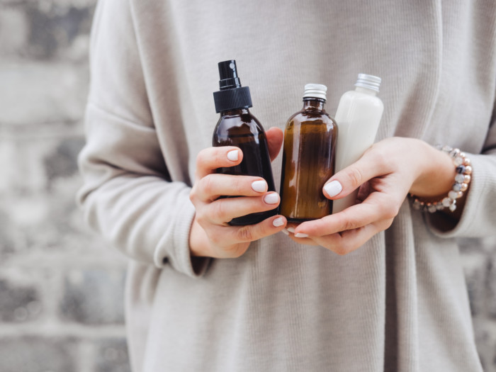 A woman holding 3 bottles of essential oil