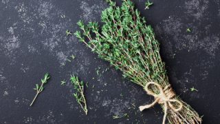 A bunch of fresh thyme herb on a black background