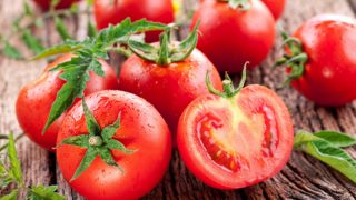 A close-up view of red tomatoes on a wooden table