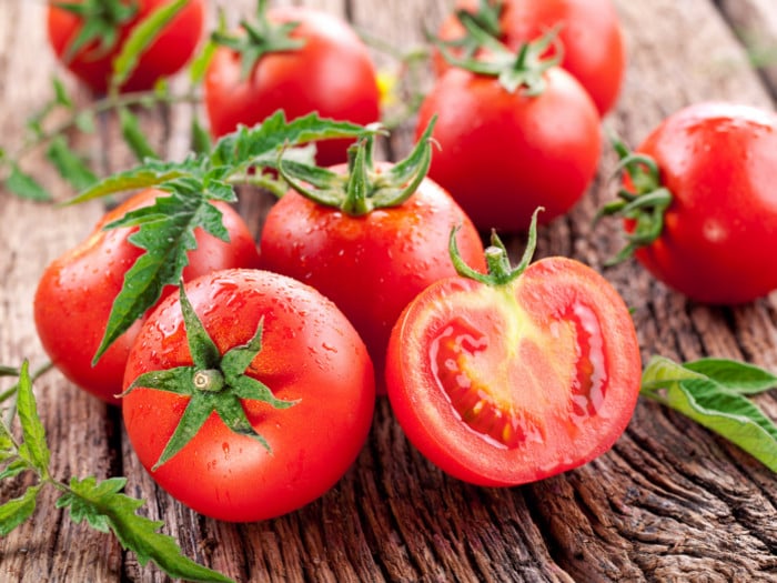 A close-up view of red tomatoes on a wooden table