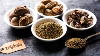Ancient Triphala powder in a spoon with other spices