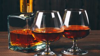 Brandy in a small bottle with two glasses next to it