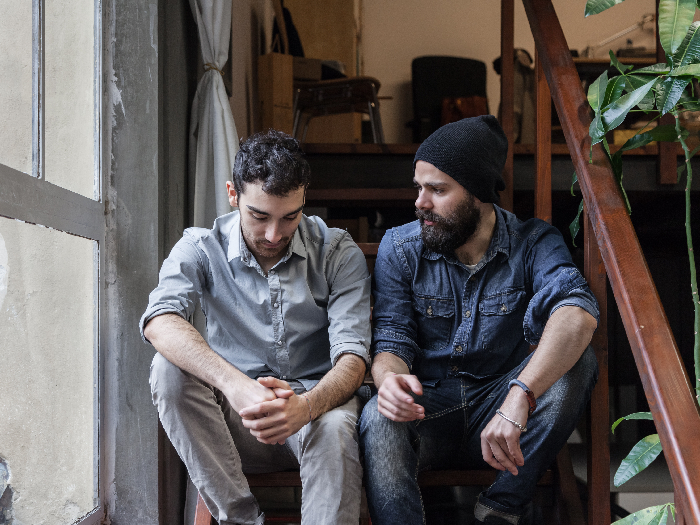Young men talking on the stairs of an office