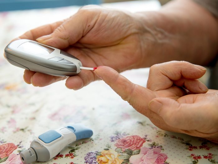 Pricking the finger for blood to test blood glucose levels
