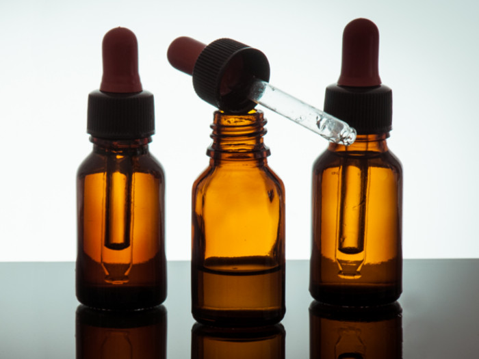 3 bottles of essential oil with dippers on a white background