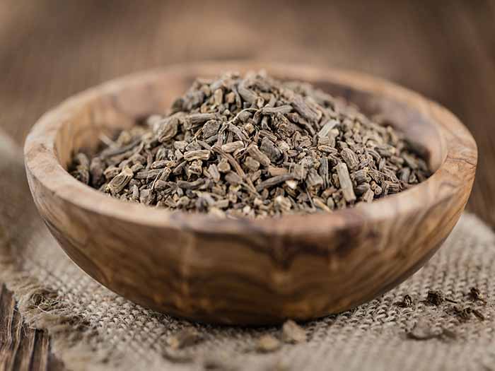Dried roots in a wooden bowl on a rustic background.