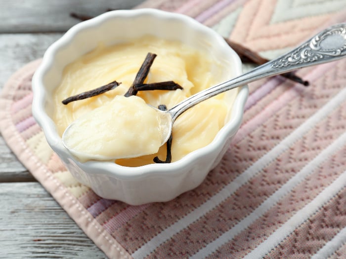 A spoonful of vanilla pudding kept on a bowl containing the same