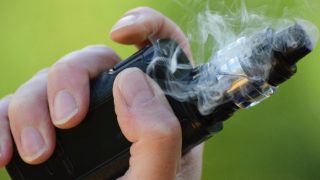 Close up of a hand holding an E cigarette