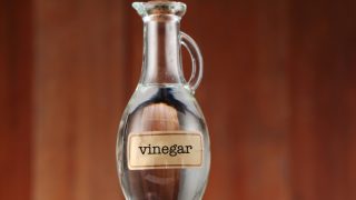 A bottle of vinegar with a label on it on a wooden table