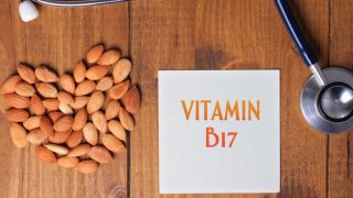 A heart shape made using almonds, a white paper with text "vitamin B17" on it and stethoscope on a wooden paper