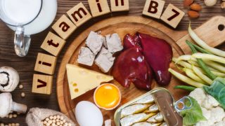 Flatline view of food containing vitamin B7: liver, canned fish, egg, jar of milk, mushroom, beans, nuts, and vegetables.