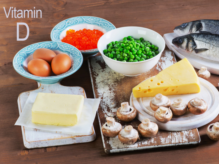 A tray of butter, eggs, mushrooms, cheese slice, peas, and fish
