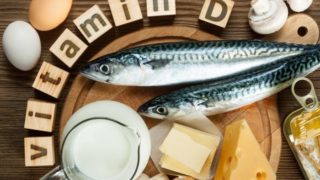 Vitamin D written in blocks with vitamin D-rich foods like eggs, fish, and cheese