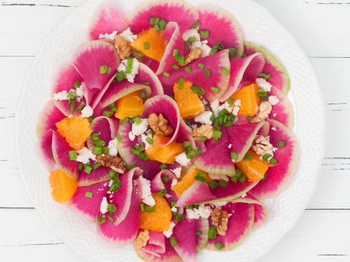 Salad with watermelon radish and oranges with goat cheese sprinkled on top