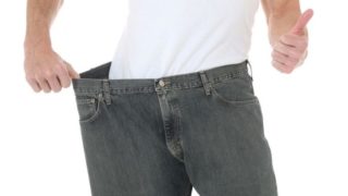 A man wearing oversize jeans depicting weight loss