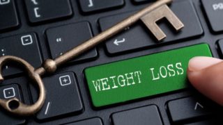 A keyboard having a key named 'weight loss' in green color