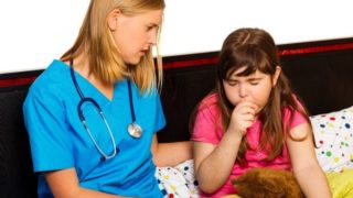 A lady doctor examining a young girl who is suffering from whooping cough