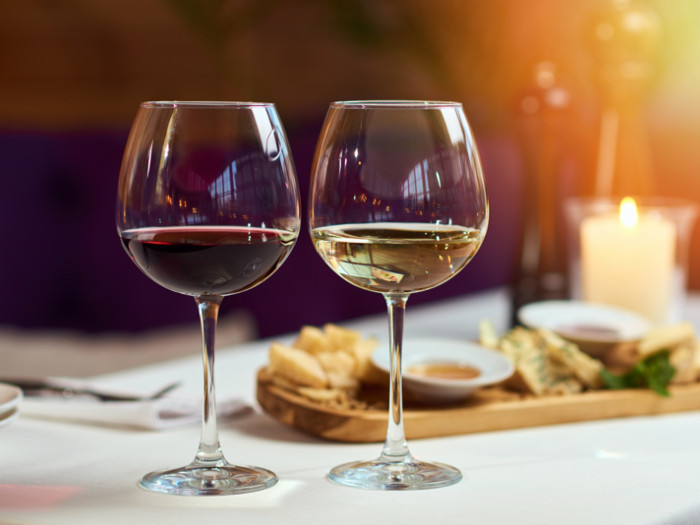 Close up of 2 glasses of red and white wine on a table