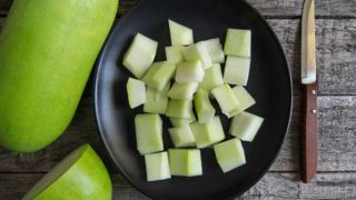 Diced winter melon cubes in a plate with knife