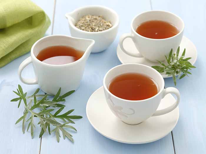 Three cups of tea on a white wooden surface