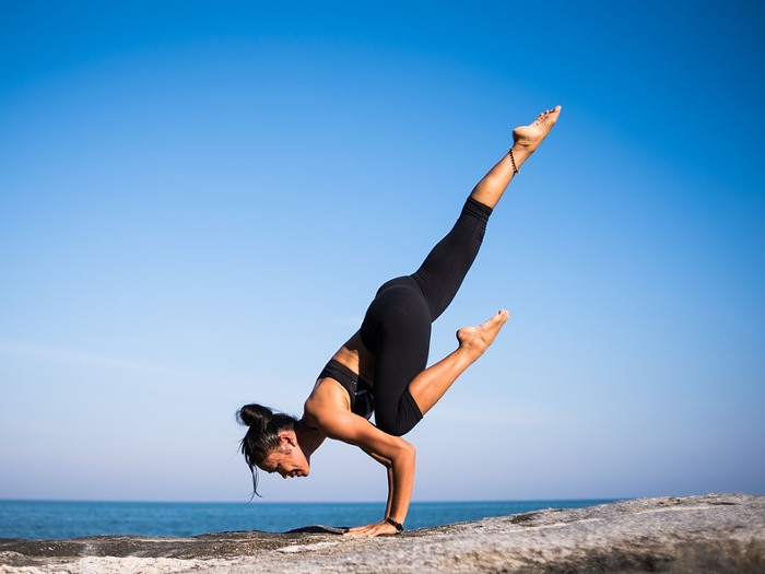 A woman performing yoga against the background of an ocean